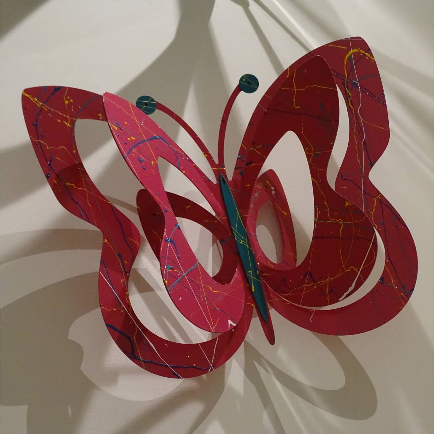 Mariposa Roja con Salpicaduras Azules y Amarillas